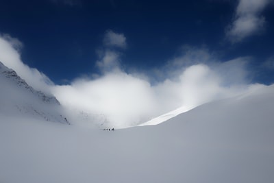 人们走在雪多云的天空下
